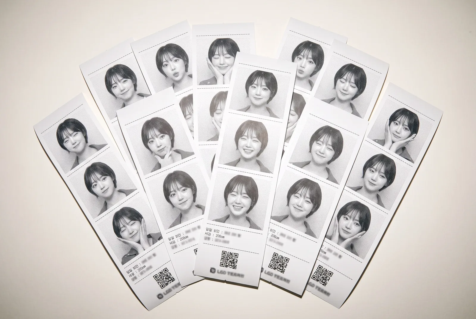 กองใบเสร็จภาพที่พิมพ์แล้ว คลี่เรียงซ้อนกันบนกระดาษ ถ่ายด้วยแฟลช